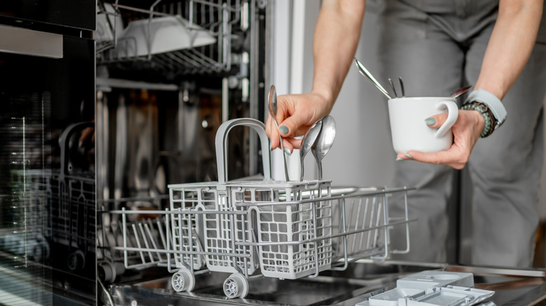 loading silverware basket in dishwasher