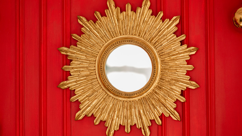 red painted wall with gold statement mirror