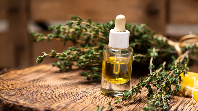 bottle of thyme oil and thyme sprigs