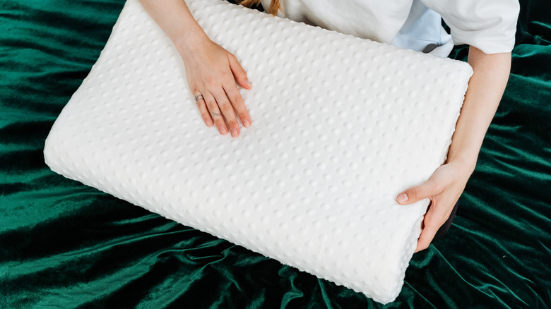 Person holding a memory foam pillow