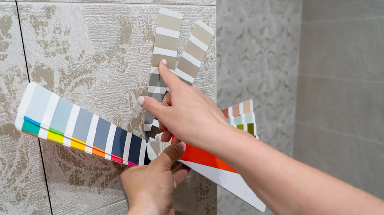 Person picking paint swatches for bathroom