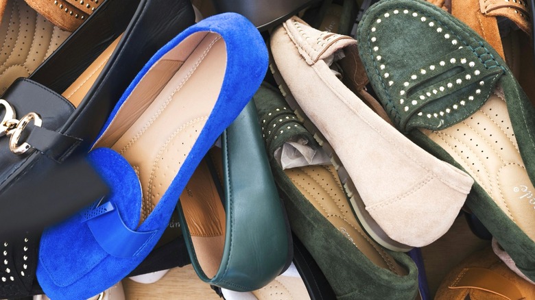 Pile of women's shoes in blue, black, tan, and green