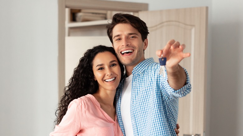 Couple smiling with home keys