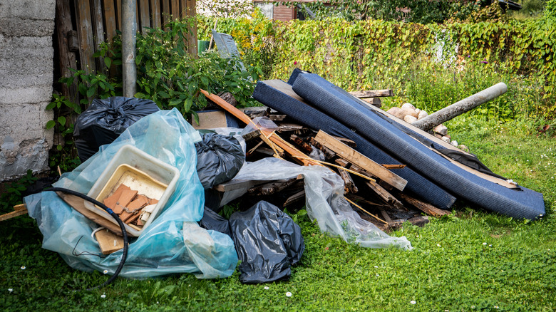 Trash bags and broken furniture in yard