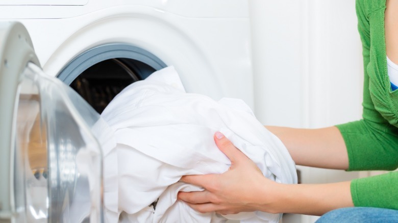 Woman removing white clothes from dryer