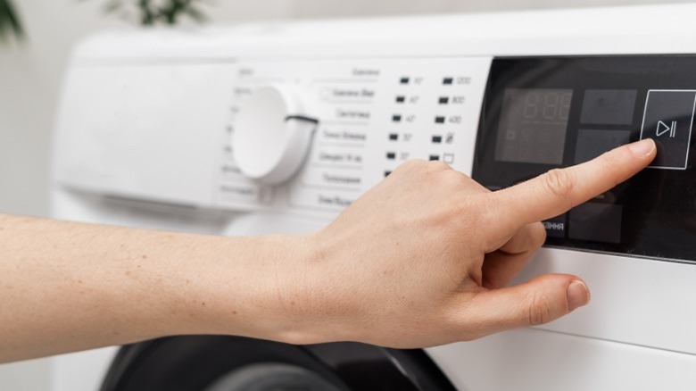 Hand adjusting setting on washing machine