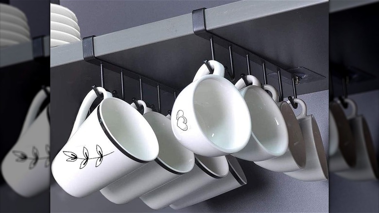 white mugs hanging below shelf