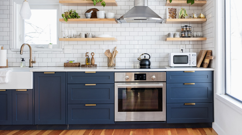 A navy kitchen has t-bar handles