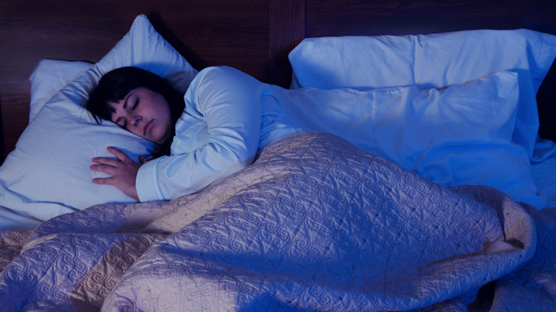 Woman sleeping in dark bedroom