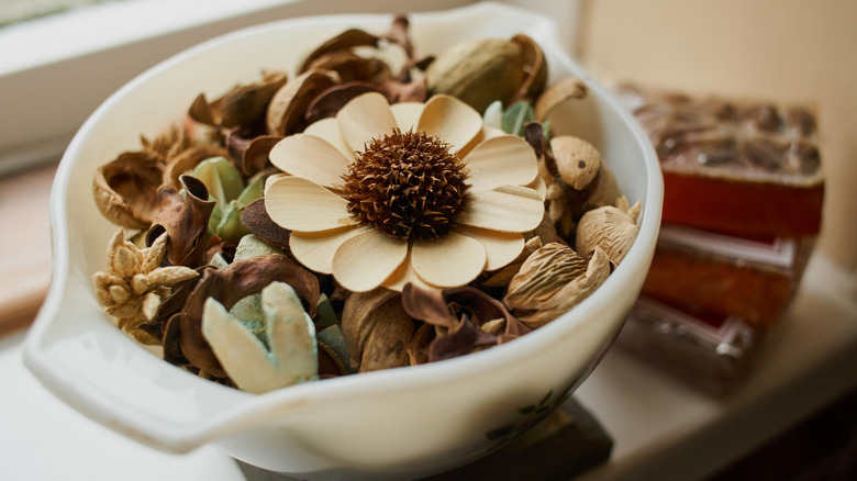 A pot of potpourri sitting on a windowsill.