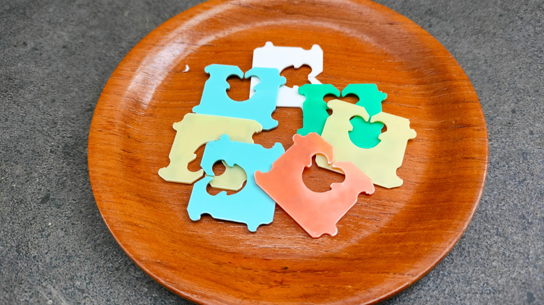 Stack of colorful bread tags on a wooden plate