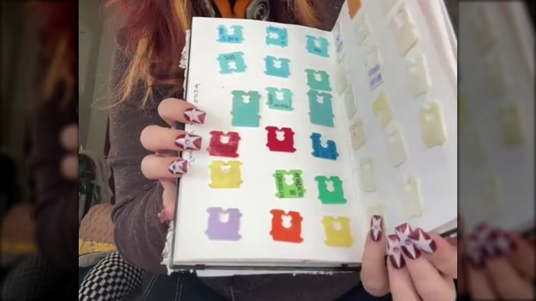 Person holding a junk journal with plastic bread tags on the pages