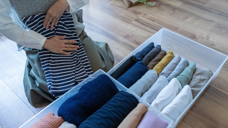 Putting clothes in plastic bins