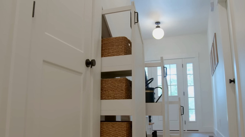 Storage shelves slide out from under a staircase