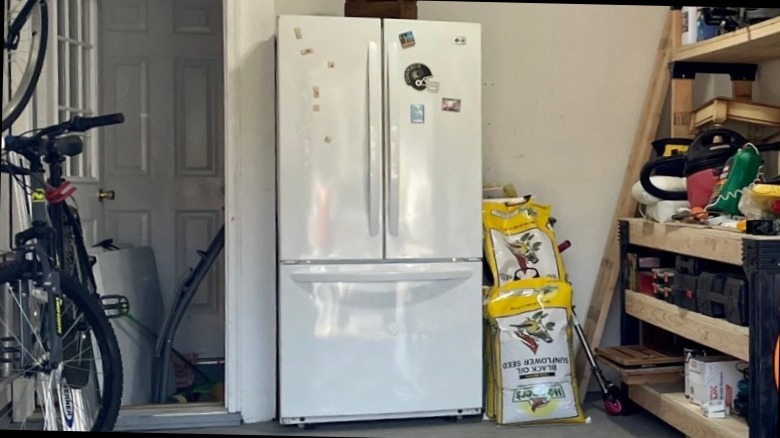 A double-doored fridge in a garage.