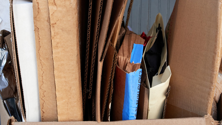 Cardboard boxes broken down and stored inside another cardboard box in the garage.