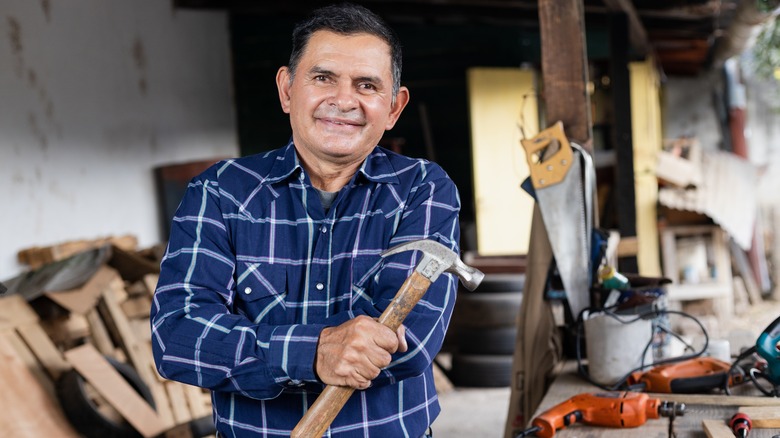 Carpenter in workshop holding hammer