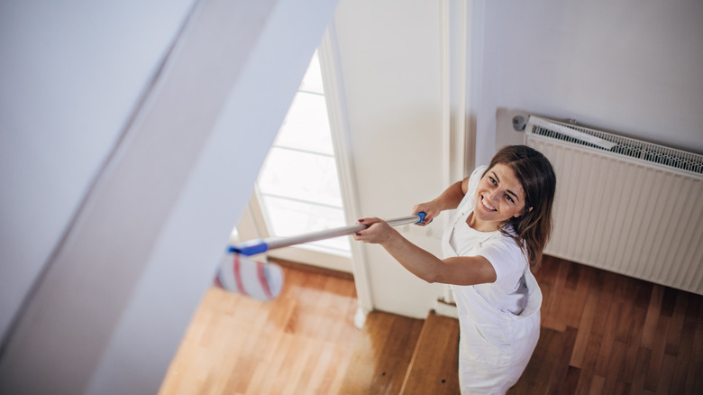 Woman painting her ceiling