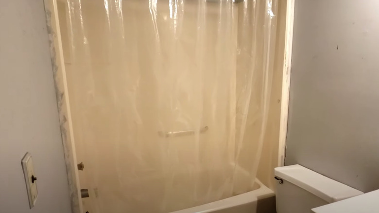 yellow bathtub with clear curtain