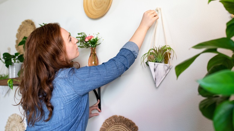 woman decorating living room with plants