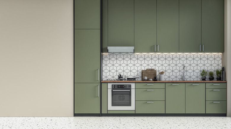 Photo showing nice-looking kitchen with green cabinets and an empty wall to the left