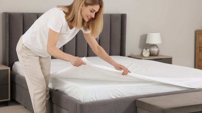 Putting sheet on bed