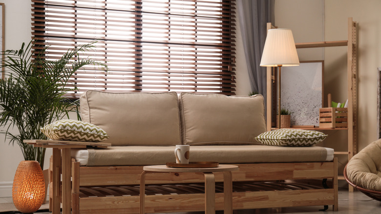 Wood venetian blinds behind sofa
