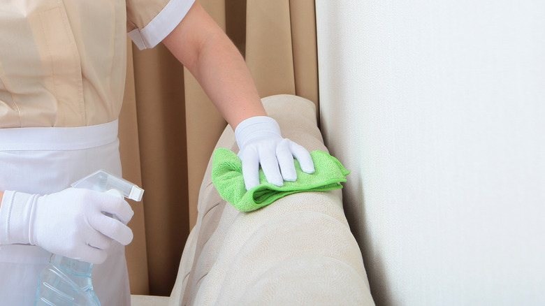 person wiping down suede couch