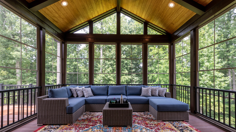 sunroom with blue couch and table