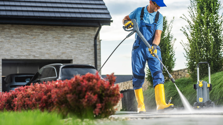 A man pressure washing his driveway.