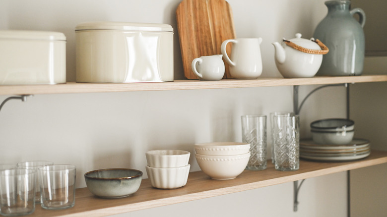 Two wall-mounted shelves decorated with kitchen wares