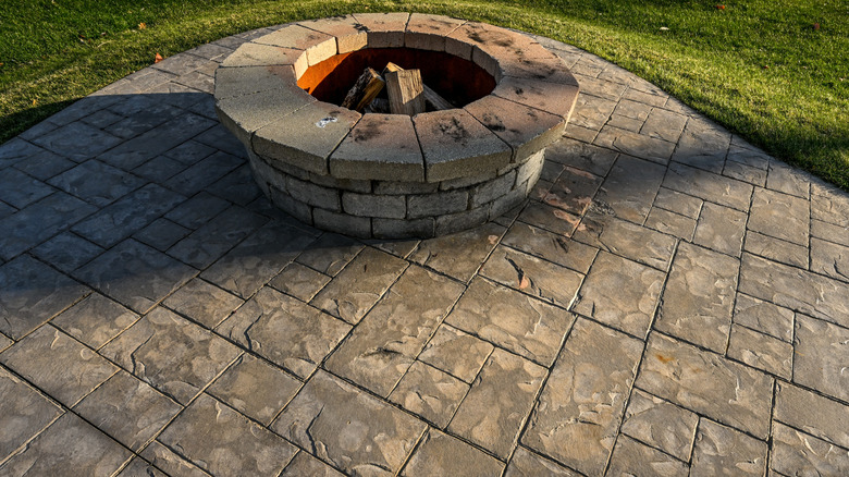 A low maintenance stamped concrete patio with a fire pit