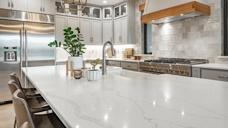 Well-lit farmhouse-style kitchen with quartz countertops.