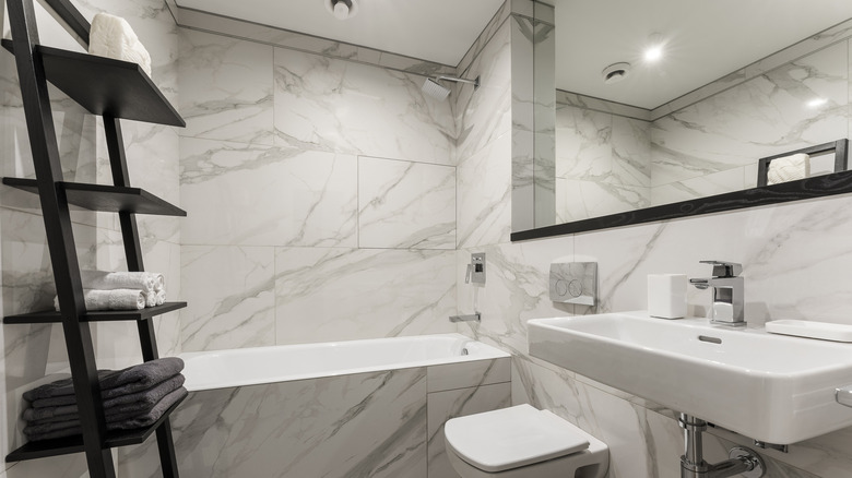 A modern bathroom with a leaning towel shelf