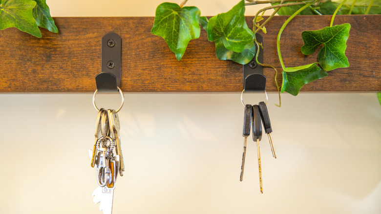 Keys hanging from stained wood key rack