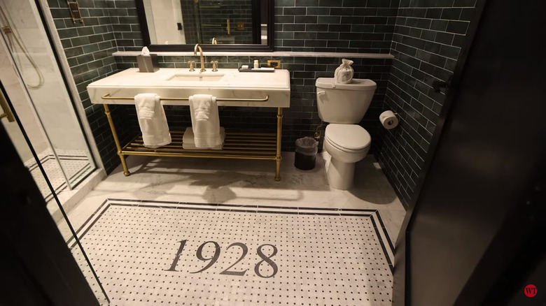 A bathroom in Hotel 1928 with mosaic floor and green subway tiles