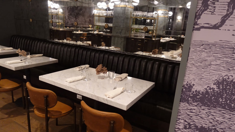 Banquette with smoky mirrors and black and white wallpaper in The Brasserie