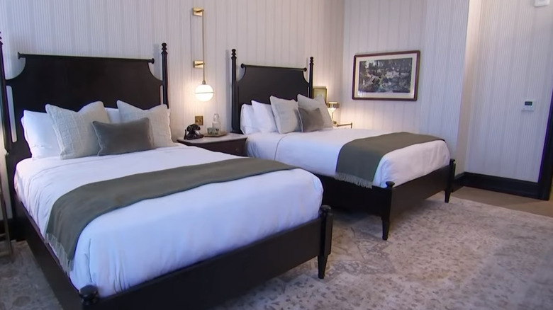 Two black Chippendale-style beds with white linen in Hotel 1928