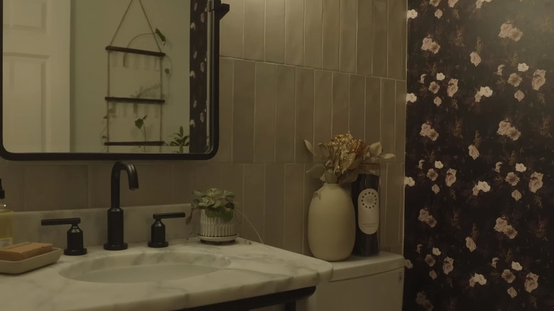 Powder bathroom with dark, floral wallpaper