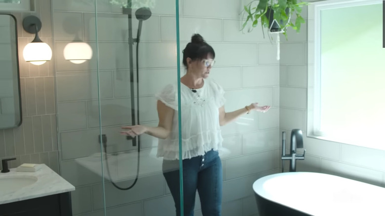 Tub with black exterior against white tiles and window