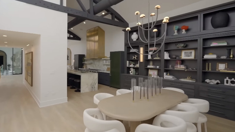 Dining area with oval table, white chairs, and black built-ins