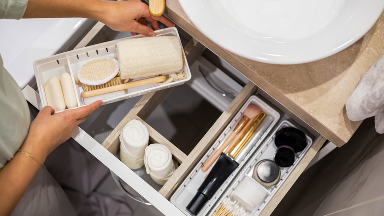 Person organizing bathroom drawers