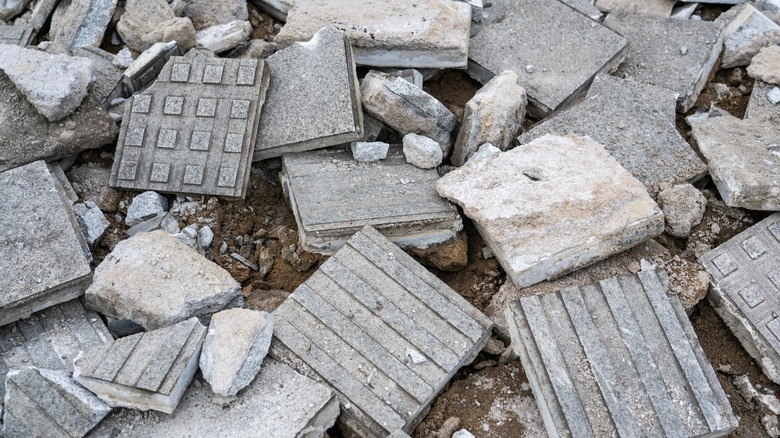 A pile of broken concrete paver pieces in various shapes and sizes.