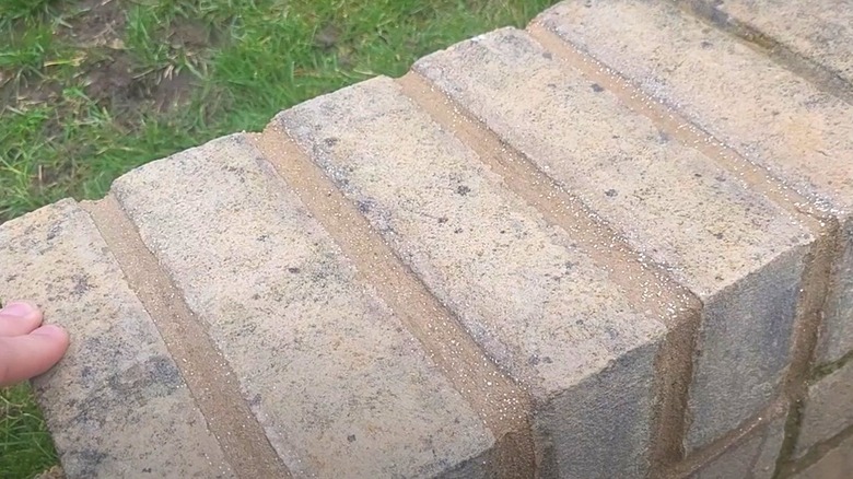 Closeup of brick pavers with gold glitter mortar between them