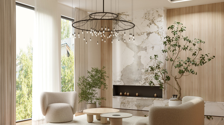 A round, black chandelier with many bulbs in neutral living room