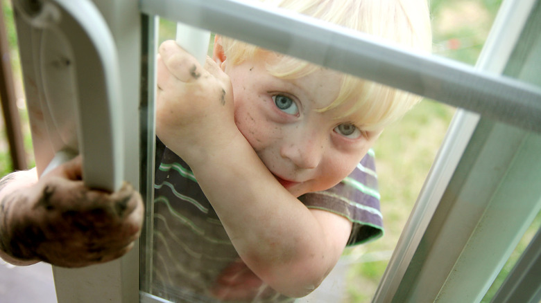 child opens glass door