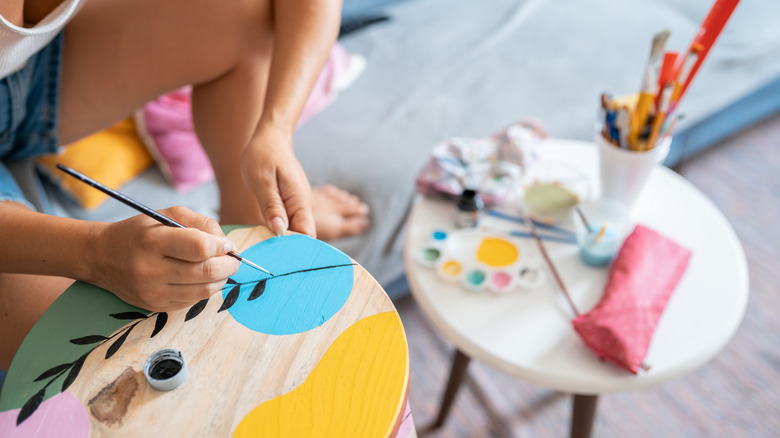 Woman painting a wood round