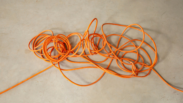 Orange tangled extension cord laying on the floor