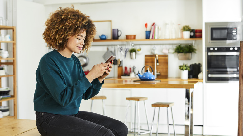 Woman uses her phone to organize her home