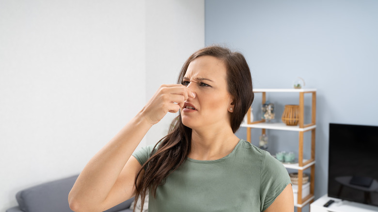 A woman holding her nose